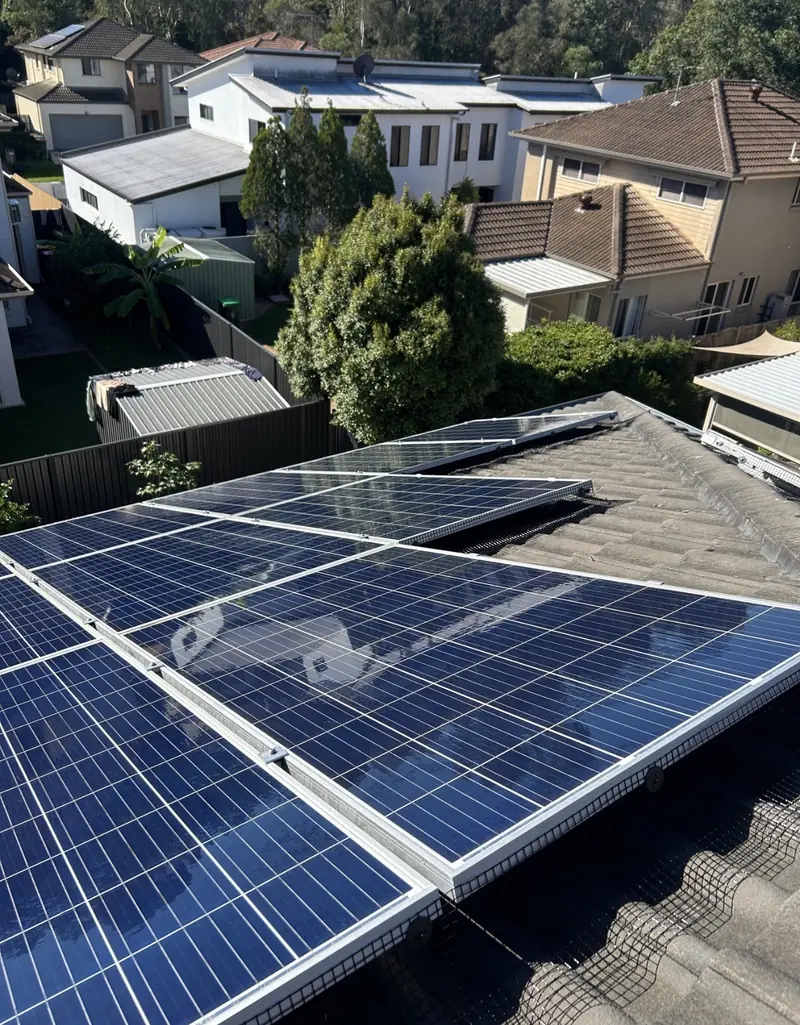 Solar panel bird proofing in Everton Park: Blue polycrystalline solar panels with edge mesh on a grey tile roof among neighbouring houses