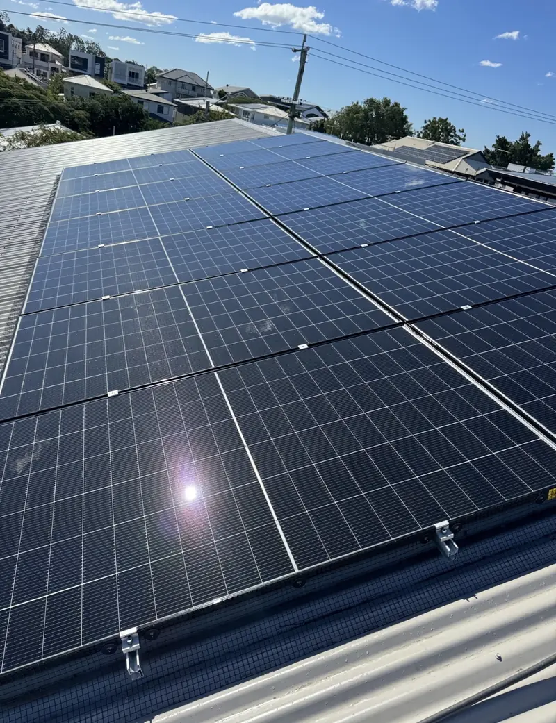 Solar panel bird proofing in North Lakes: Wide solar array with mesh and clips along its lower edge on a pale metal roof