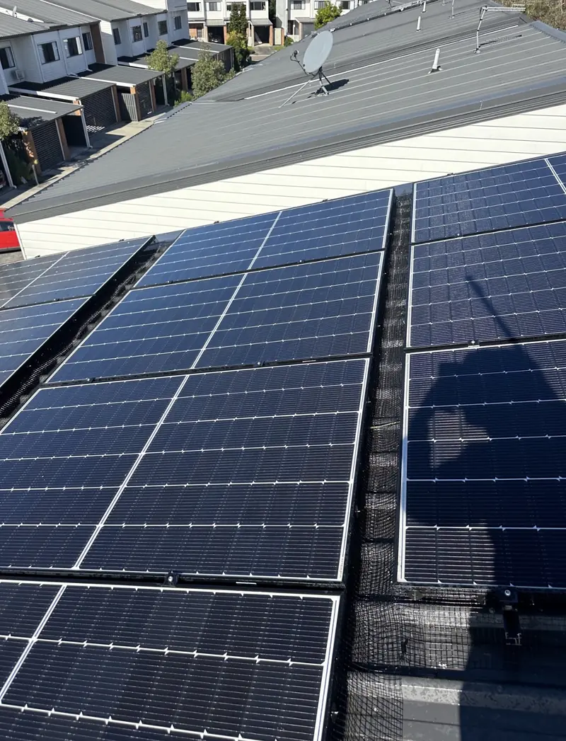 Solar panel bird proofing in Parkinson: Black bird mesh fitted in the channel between solar arrays on a dark metal roof