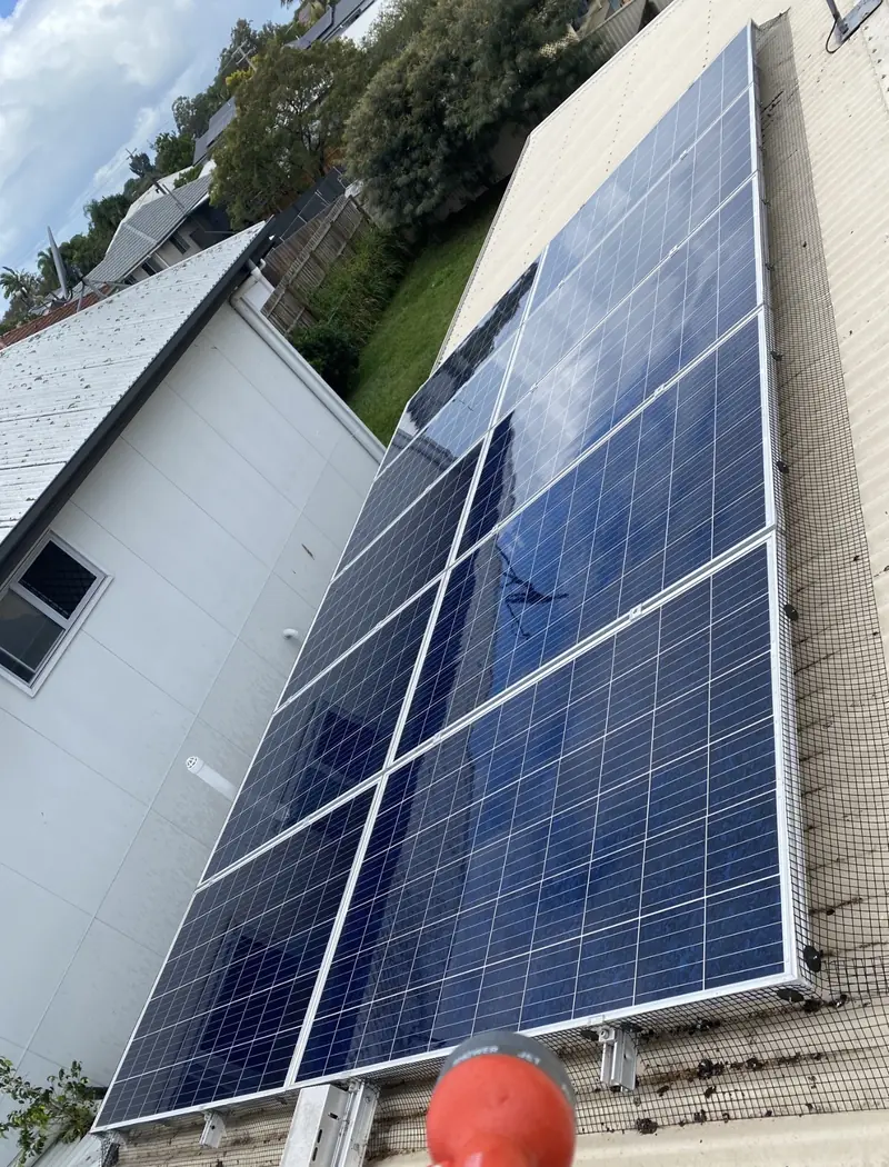 Solar panel bird proofing in Wakerley: Blue polycrystalline solar panels with black edge mesh and clips on a cream corrugated metal roof